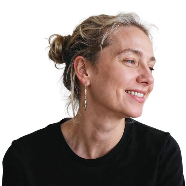 Smiling woman in her forties turning to show a defined jawline and neck, the areas Endolift treats.