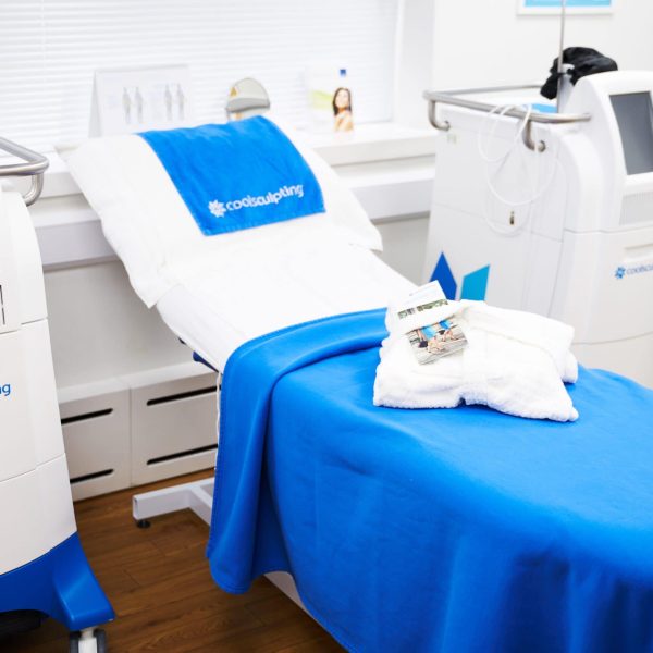 Medical treatment bed with CoolSculpting equipment in a clinic room.