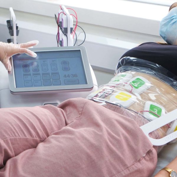 Patient undergoing truFlex treatment with medical device and electrodes attached.