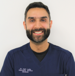 Dr Kam Lally, aesthetic doctor at MediZen, smiling in navy scrubs.