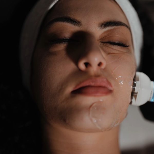 Woman receiving a facial treatment with a device at MediZen clinic.
